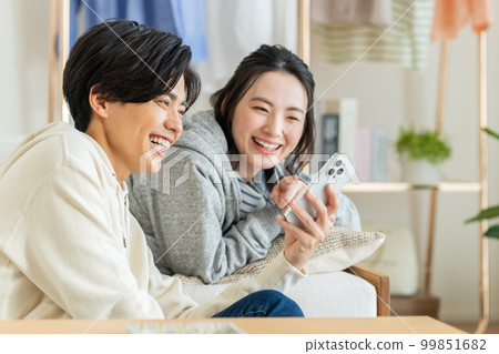 A young couple relaxing in the living room A young couple relaxing in the living room 99851682