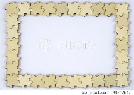 Frame of wooden puzzles on a white background. Blank mock up for design or lettering. Frame of wooden puzzles on a white background. Blank mock up for design or lettering. 99852642