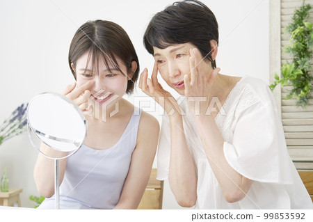 Mother giving daughter skincare advice at home Mother giving daughter skincare advice at home 99853592