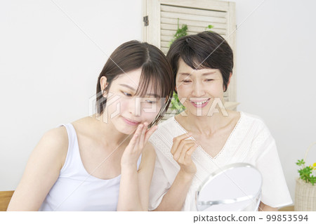 Mother giving daughter skincare advice at home Mother giving daughter skincare advice at home 99853594