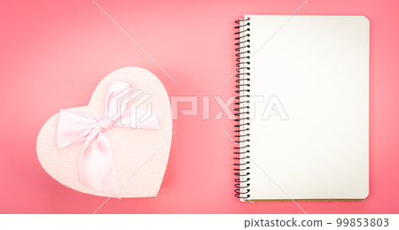 Blank notebook and heart shaped gift box on pink background, top view. 99853803