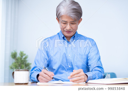 Middle-aged man studying in the living room 99853848