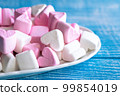 Plate with marshmallows in the form of hearts, close up. 99854019