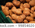 Raw dirty potatoes in the supermarket, close-up. 99854020
