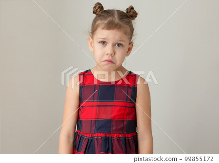 Sad and unhappy child because of distress, pain or sorrow on grey background caucasian kid little girl of 6 7 years in red plaid dress Sad and unhappy child because of distress, pain or sorrow on grey background caucasian kid little girl of 6 7 years in red plaid dress 99855172