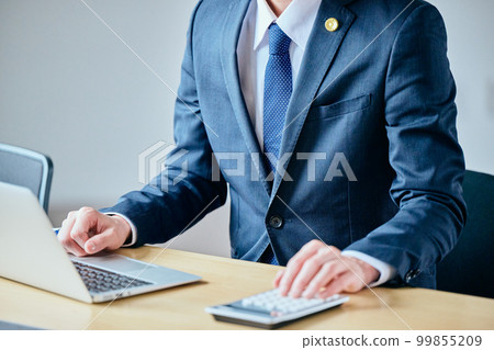 Young lawyer doing calculations on a calculator Young lawyer doing calculations on a calculator 99855209