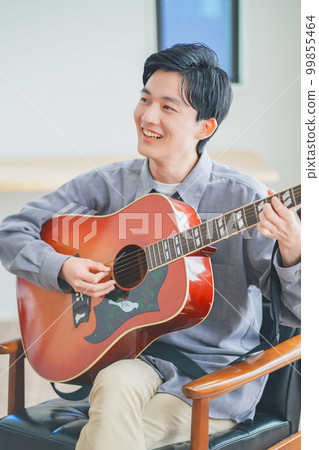 在家彈原聲吉他的年輕人 99855464