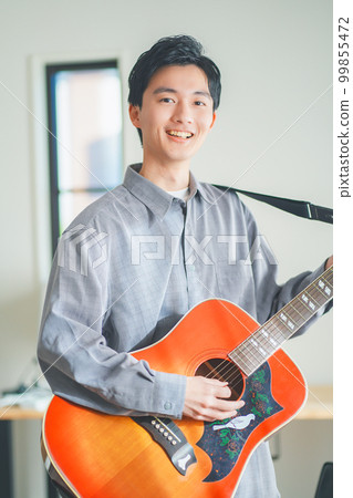 在家彈原聲吉他的年輕人 在家彈原聲吉他的年輕人 99855472