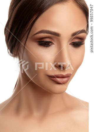 Close up portrait of a brunette nude model girl with professional evening make-up and plump lips, posing isolated on white background. 99857847