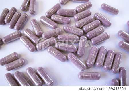 Pink capsules with additives on a white background. Pills and medicines. Tart cherry additives, vitamins, minerals, plant extracts and other beneficial substances 99858234