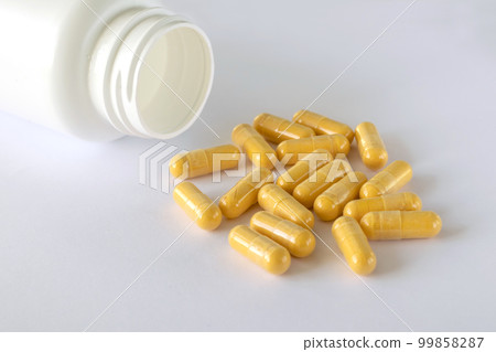 Vitamin Coenzyme Q10 on the white background next to the lying jar of supplements. To prevent aging. Pills and medicines Vitamin Coenzyme Q10 on the white background next to the lying jar of supplements. To prevent aging. Pills and medicines 99858287