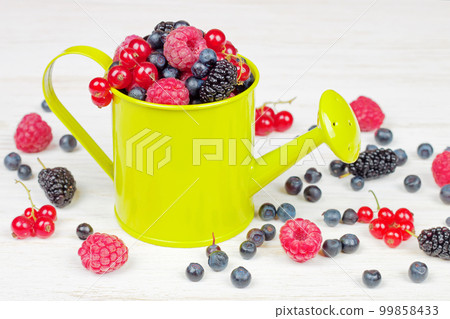 Mix of berries in small decorative light green watering can Mix of berries in small decorative light green watering can 99858433