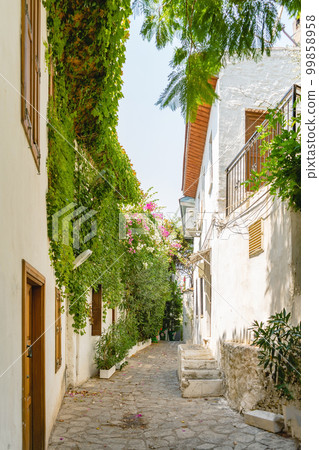Narrow street in old town of Marmaris, Turkey . Beautiful scenic old ancient white houses with flowers. Narrow street in old town of Marmaris, Turkey . Beautiful scenic old ancient white houses with flowers. 99858958