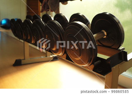 Closeup dumbbells on the steel rack in the training room 99860585