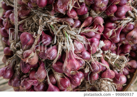 Top view of shallots aka red onion on basket for sell in Thai market Top view of shallots aka red onion on basket for sell in Thai market 99860937