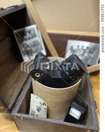 an old SLR camera in a frame and in a chest an old SLR camera in a frame and in a chest 99861456
