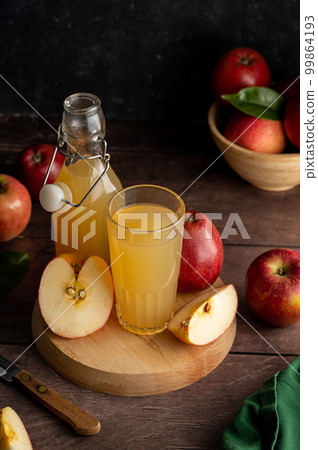 Apple juice drink with fresh red apples, wooden background. dark bakground Apple juice drink with fresh red apples, wooden background. dark bakground 99864193