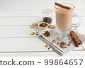 A glass of hot Indian masala tea brewed with aromatic spices and milk 99864657