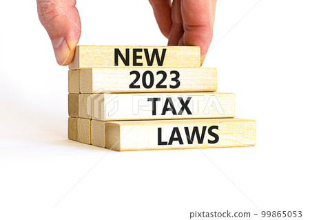 New 2023 tax laws symbol. Concept words New 2023 tax laws on wooden blocks. Beautiful white table white background. Businessman hand. Business new 2023 tax laws concept. Copy space. 99865053
