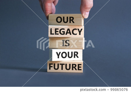 Legacy and future symbol. Concept words Our legacy is your future on wooden blocks. Beautiful grey table grey background. Businessman hand. Business legacy and future concept. Copy space. 99865076