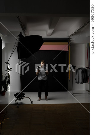 Professional handsome bearded male photographer with bunch of vintage photo cameras in photo studio. Professional handsome bearded male photographer with bunch of vintage photo cameras in photo studio. 99867580