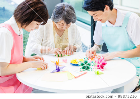 A senior woman folding origami and a caregiver Photography cooperation "LINK FOREST" A senior woman folding origami and a caregiver Photography cooperation "LINK FOREST" 99873210