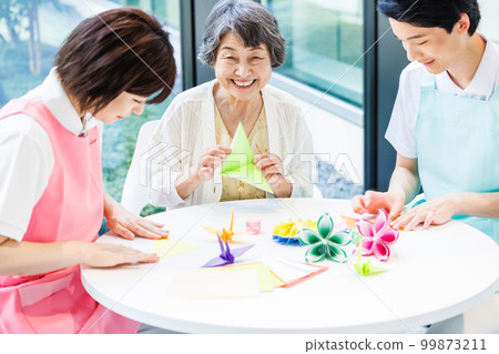A senior woman folding origami and a caregiver Photography cooperation "LINK FOREST" A senior woman folding origami and a caregiver Photography cooperation "LINK FOREST" 99873211