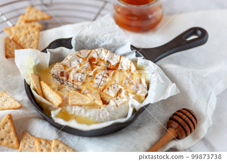 Camembert soft french cheese cooked in the oven with honey and thyme 99873738