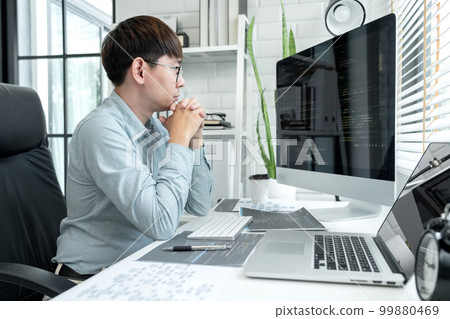 Male programmer is programing to developing program app and website of corporate while working to checking program code and debugging on multiple screen at modern software office 99880469