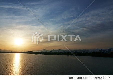 A spring morning sky with various clouds and a river that reflects the sky ・220502am 99881287