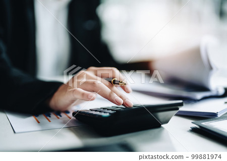 accountant, Auditor, Self-Employed, Finance and Investment, tax calculation and budget, Asian female entrepreneur using a calculator to calculate. Company business results document 99881974
