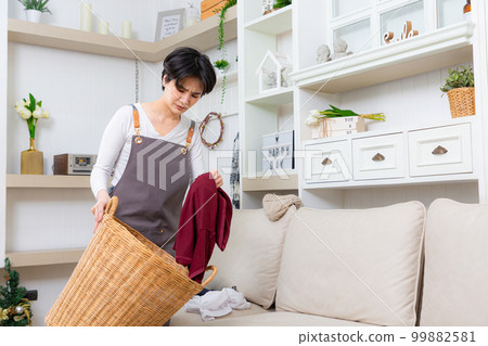 Young asian woman boring doing laundry at living room. 99882581
