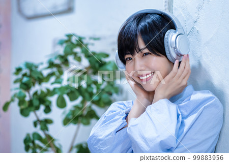 A woman listening to music with headphones 99883956