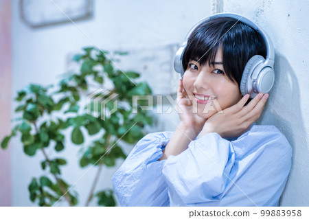 A woman listening to music with headphones 99883958