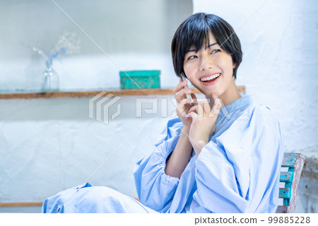 A woman who speaks with a smartphone A woman who speaks with a smartphone 99885228