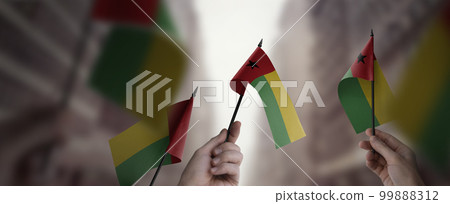 A group of people holding small flags of the Guinea Bissau in their hands 99888312