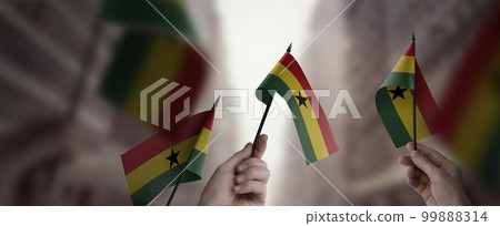 A group of people holding small flags of the Ghana in their hands 99888314