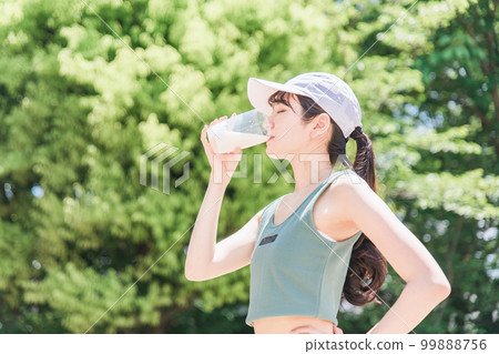 Woman drinking protein while training in the park 99888756