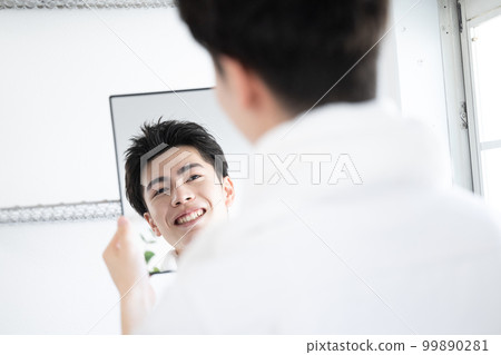 男人在鏡子特寫鏡頭中檢查自己的皮膚和外表 99890281