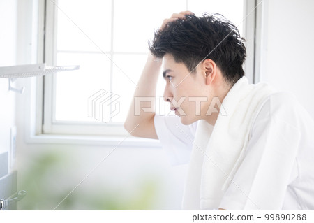 一個男人早上在臉盆裡擔心頭髮的狀態 99890288