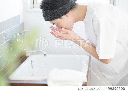一個男人在洗臉盆裡用髮帶和綠色前模糊洗臉 一個男人在洗臉盆裡用髮帶和綠色前模糊洗臉 99890300