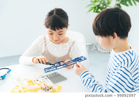 Girls and boys making plastic models 99892897