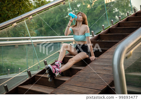 A long-haired young girl relaxes after roller-skating. A long-haired young girl relaxes after roller-skating. 99893477