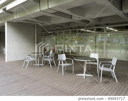 An outdoor deck with chairs and tables at a public facility 99893717