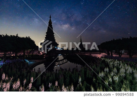 Night sky time lapse of moving Milky Way and stars under moon light at Phra Mahathat monuments on Doi Inthanon 99894588