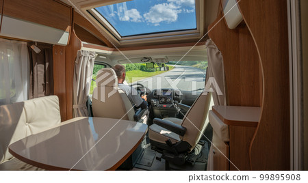 Man driving on a road in the Camper Van RV 99895908