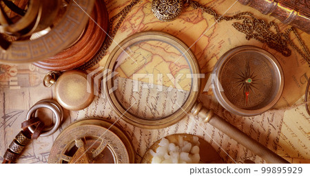 Vintage style travel and adventure. Vintage old compass and other vintage items on the table. 99895929