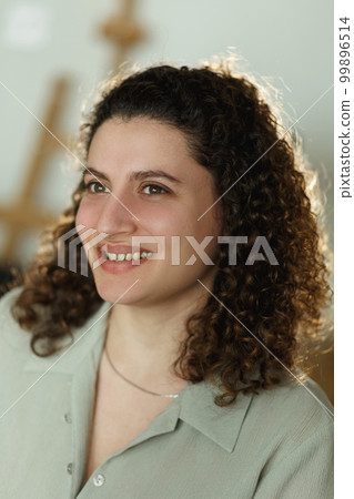 Portrait of a young, curly mixed race student or businesswoman in room in a library or office 99896514