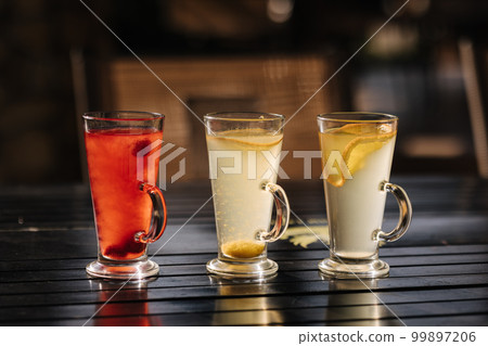 Tree different types of tea in glass cups on wooden table Tree different types of tea in glass cups on wooden table 99897206