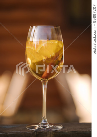 Glass of white dry wine with slice of lemon on wooden table Glass of white dry wine with slice of lemon on wooden table 99897207